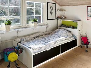 uma cama num quarto com duas janelas em Holiday home EKERÖ em Ekerö