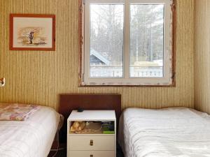 um quarto com 2 camas individuais e uma janela em Holiday home GRISSLEHAMN XV em Grisslehamn