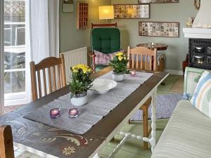 Holiday home Ronneby XV في رونيبي: طاولة طعام عليها زهور وشموع