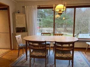 a dining room table with chairs and a large window at Holiday home Nösund VI in Nösund