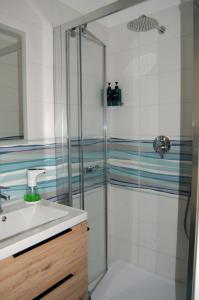uma casa de banho com um chuveiro e um lavatório. em Appartamento Badiella em Trapani