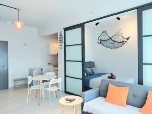 Cette chambre comprend un canapé, un lit et une table. dans l'établissement Jesselton Quay Citypads Kota Kinabalu, à Kota Kinabalu