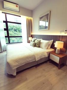- une chambre avec un lit, deux lampes et une fenêtre dans l'établissement Jesselton Quay Citypads Kota Kinabalu, à Kota Kinabalu