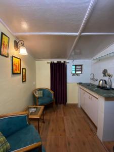 穆索里Landour Vintage Homestay的一间厨房和一间带沙发和桌子的客厅