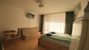 a bedroom with a bed and a couch and a window at William's fourth pretty studio-Crown Fort Noks in Sveti Vlas