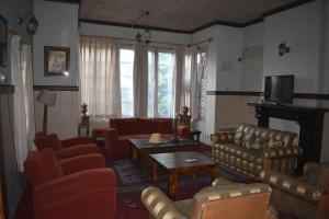 - un salon avec des canapés en cuir et une télévision dans l'établissement Dak Hermitage, à Srinagar