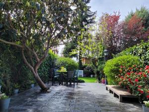 un jardín con sillas, una mesa y un árbol en La Casa Bonita Cercedilla, en Cercedilla