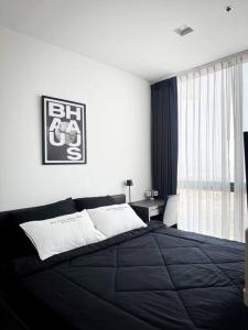 a bedroom with a black bed and a window at HMJ4 2BR stylish apartment on 36th floor KKC City center in Khon Kaen