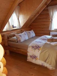 a bedroom with two beds in a log cabin at Cabana Razesilor in Gura Humorului