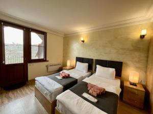 a hotel room with two beds and a window at The Hill Guest House in Yerevan