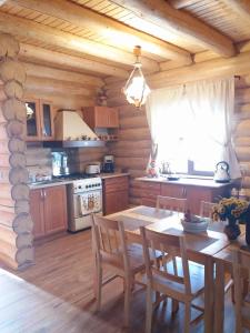 eine Küche mit einem Tisch und Stühlen in einer Hütte in der Unterkunft Cabana Razesilor in Gura Humorului