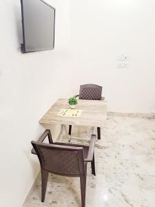 - un bureau avec une chaise, une table et un miroir dans l'établissement Hotel Satguru Indrapuram, Shaktikhand, à Ghaziabad