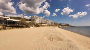 a sandy beach with some buildings and the ocean at William's fourth pretty studio-Crown Fort Noks in Sveti Vlas