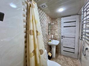 a bathroom with a shower curtain and a sink at The Hill Guest House in Yerevan