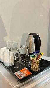 Una bandeja con dos vasos y una cafetera. en Bothabelo Bed and Breakfast en Phalaborwa