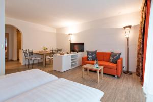 une chambre d'hôtel avec un lit, un canapé et une table dans l'établissement Hotel Piz St. Moritz, à Saint-Moritz