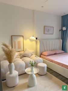 a bedroom with a bed and a couch and a table at Bunnys Homes - Managed by WiWi - Vinhomes Ocean Park in Hanoi