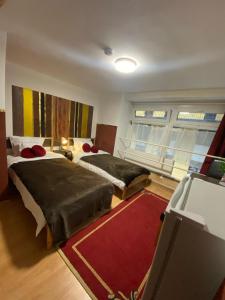 a bedroom with two beds and a red rug at Allaga House in Budapest