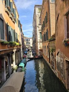 um canal entre dois edifícios com barcos em Cozy Studio with Canal View em Veneza