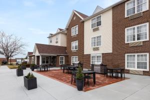 un patio di fronte a un edificio con tavoli e sedie di Candlewood Suites St Louis St Charles, an IHG Hotel a St. Charles