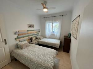 a small room with two beds and a window at Casa Feliz in Beniarbeig