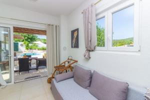 a living room with a couch and a view of a patio at Kuća za odmor Laurus s bazenom in Kukljica