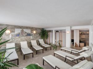 a waiting room with white chairs and a brick wall at Sun & snow in Kühtai in Kühtai