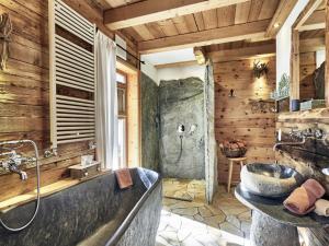 a bathroom with a large tub and a sink at Felsenhütte Modern retreat in Grän