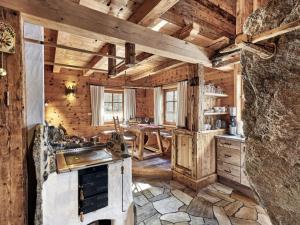 uma cozinha com um fogão e uma mesa num quarto em Felsenhütte Modern retreat em Grän