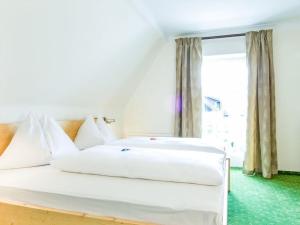 韋爾特湖畔費爾登的住宿－Little Garden-Villa，一间卧室设有两张白色的床和窗户