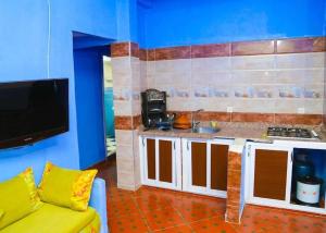 uma cozinha com um sofá amarelo num quarto em Silius em Chefchaouen