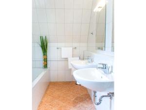韋爾特湖畔費爾登的住宿－Little Garden-Villa，白色的浴室设有两个盥洗盆和镜子