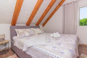 a bedroom with a large bed with two pillows at Kuća za odmor Laurus s bazenom in Kukljica +33 photos