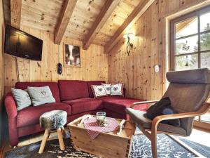 een woonkamer met een rode bank en een stoel bij at Haldensee Modern retreat in Grän