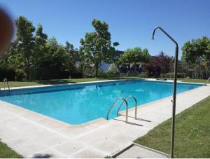 - une piscine d'eau bleue dans la cour dans l'établissement La Casa Bonita Cercedilla, à Cercedilla
