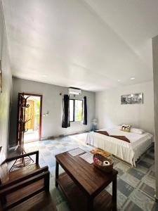a bedroom with a bed and a table in it at Angkor Piseth Homestay in Siem Reap