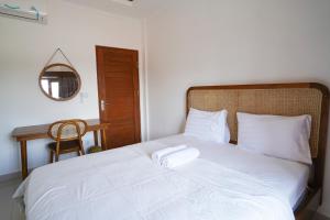 ウブドにあるメイド アルサ ホームステイのベッドルーム(白い大型ベッド1台、木製ヘッドボード付)