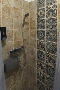 een douche met een douchekop in de badkamer bij Nice Home Apartment 2 in Abda