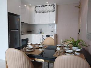 喬木提恩海灘的住宿－Copacabana Luxury sea-view room with infinity pool01，一间带餐桌和椅子的厨房和一间带白色橱柜的厨房