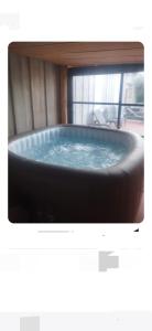 een grote hot tub in een kamer met een tv bij Gite la Boisonade in Montauban