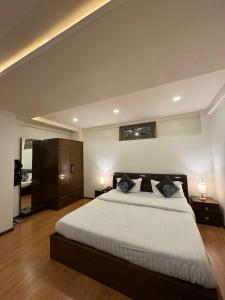 una camera da letto con un grande letto con due comodini e due lampade di Fratelli Guest House a Shillong