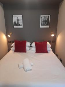 un grande letto bianco con cuscini rossi in una camera da letto di Molino nuovo a Maslianico