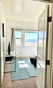 uma sala com um quarto com uma secretária e uma janela em Oceanfront Condo with Private Deck & Endless Views em Los Angeles