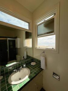 uma casa de banho com um lavatório, um espelho e uma janela em Oceanfront Condo with Private Deck & Endless Views em Los Angeles