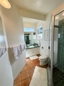 uma casa de banho com um chuveiro, um WC e um lavatório. em Oceanfront Condo with Private Deck & Endless Views em Los Angeles