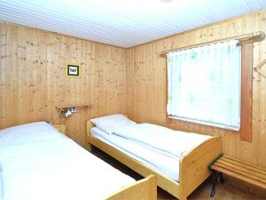 two beds in a room with a window at Welcoming bungalows in Neustadt in Neustadt/Harz