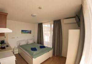 a small bedroom with a bed and a window at William's apartments - second cozy studio in Sveti Vlas +95 photos