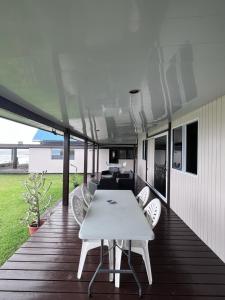 a white table and chairs on a wooden deck at Havae Lodge in Teahupoo