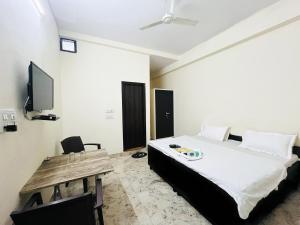 a bedroom with a bed and a tv and a table at Hotel Maharaja - Majnu-ka-tilla in New Delhi