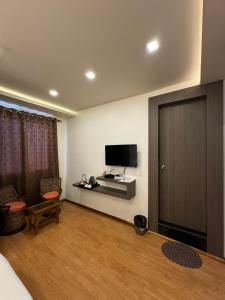 - un salon avec une télévision et une porte dans l'établissement Fratelli Guest House, à Shillong